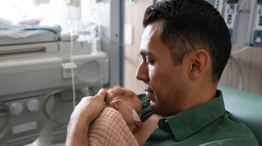 Dad holding premature baby