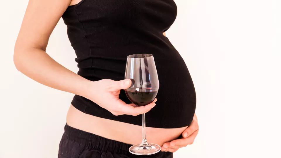 Pregnant mother with a glass of wine