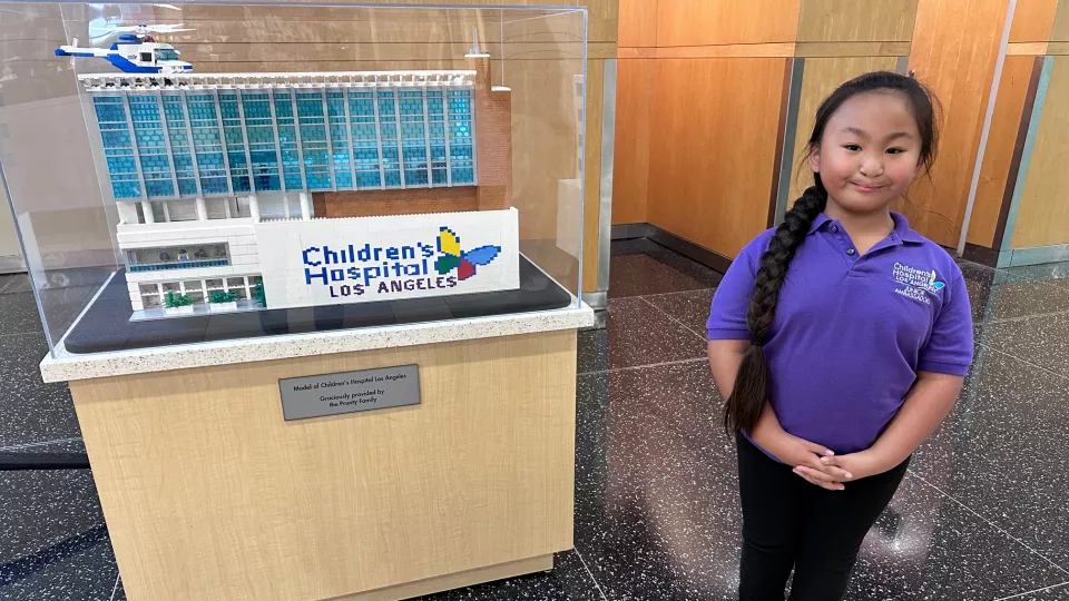 Julia Rose standing next to Lego CHLA model