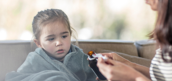 Child getting medication from mother