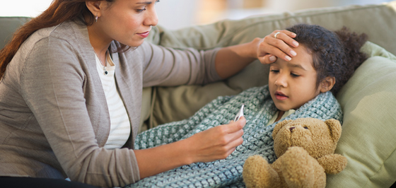 Girl getting temperature taken by mom