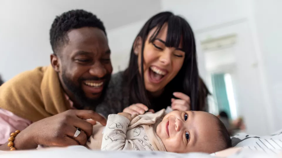 Parents playing with smiling infant