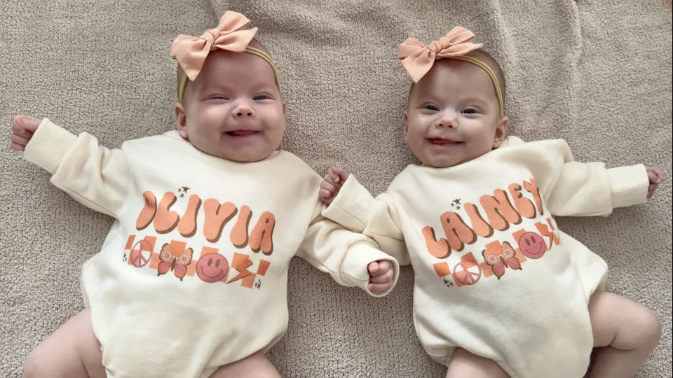 Twins wearing onesies