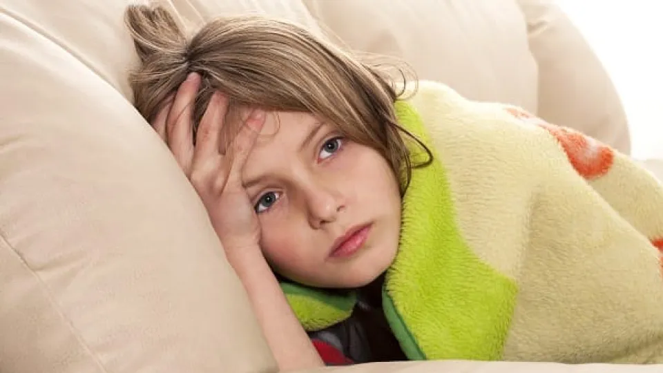 Young boy holding his head