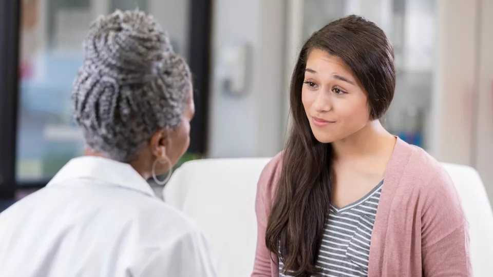 Young woman talking to doctor