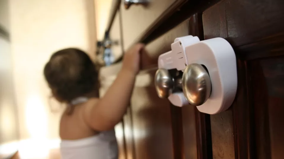 Baby with child proof locks on cabinet